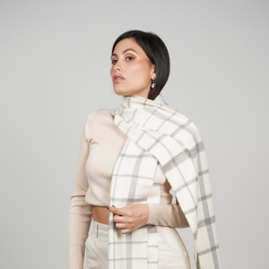 White and gray check alpaca scarf worn with neutral clothing, showcasing its timeless windowpane pattern and luxurious alpaca wool texture.