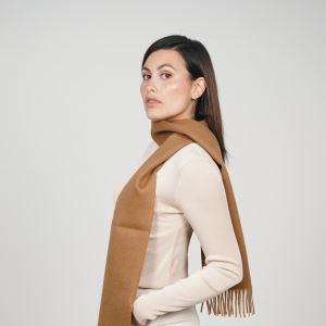 Camel alpaca wool scarf worn with neutral clothing, showcasing its elegant drape and warm natural color.