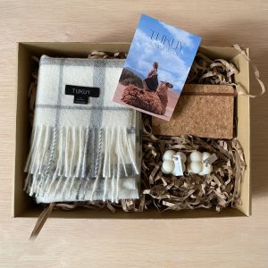 Gift box with gray and white baby alpaca scarf, artisanal candles, cork notebook, and Tukuy, perfect sustainable gift for her