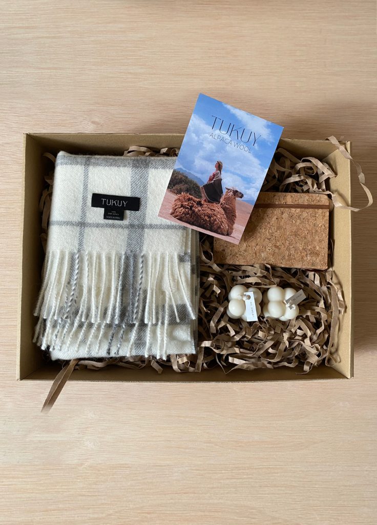 Gift box with gray and white baby alpaca scarf, artisanal candles, cork notebook, and Tukuy, perfect sustainable gift for her