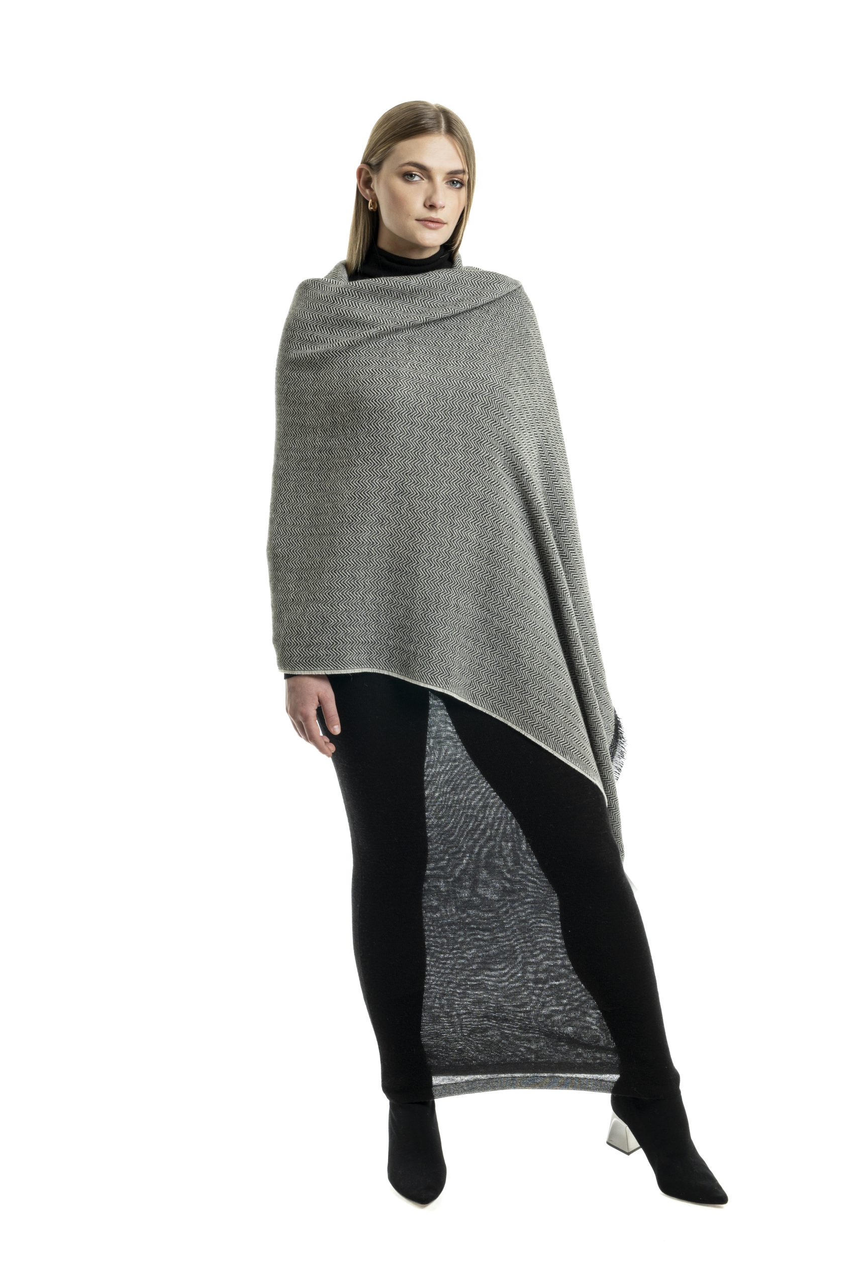 Woman wearing a dark grey baby alpaca shawl with light grey stripes from Tukuy, styled over a light black outfit