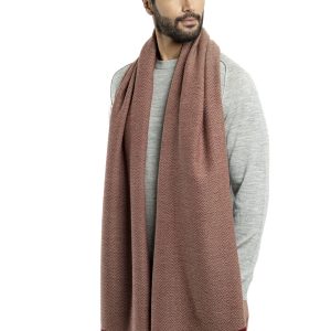 Man wearing a red herringbone-patterned baby alpaca wool scarf from Tukuy with burgundy fringed edges, styled over a light grey sweater