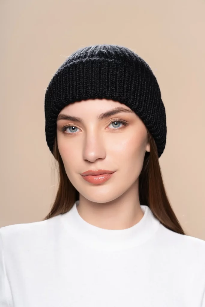 Woman wearing a black ribbed baby alpaca wool beanie from Tukuy