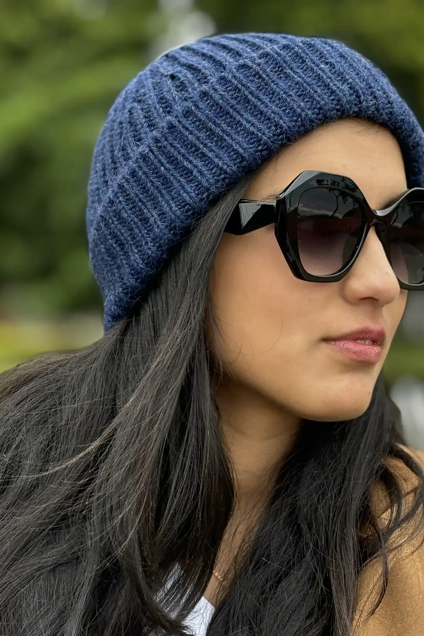 Woman wearing a blue baby alpaca wool beanie from Tukuy and sungrasses