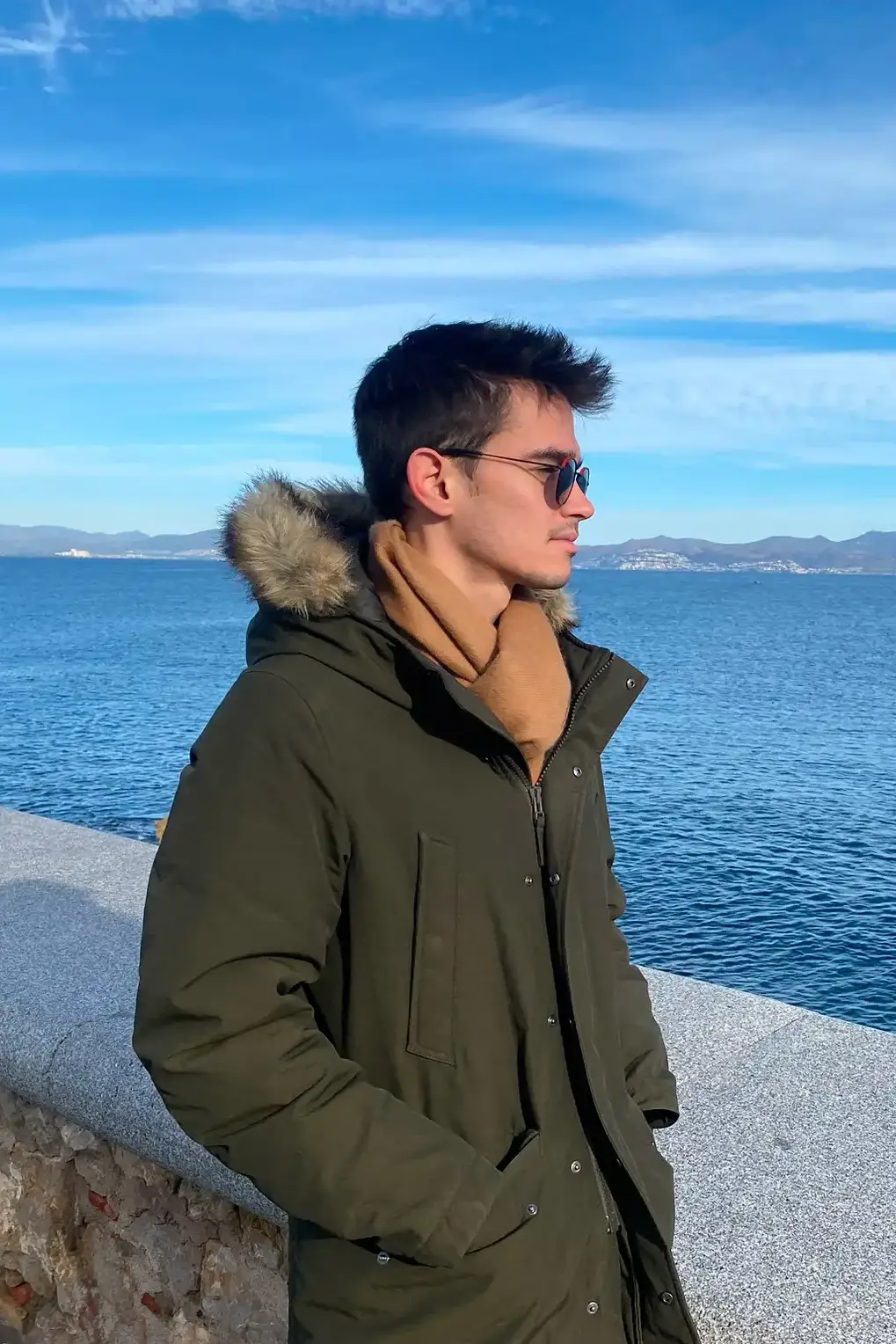 Man wearing an alpaca wool scarf in camel color by Tukuy in the beach