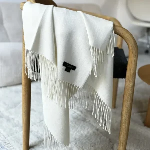 manta alpaca blanca de lana de baby alpaca de Tukuy sobre el sofá de un acogedor salón
