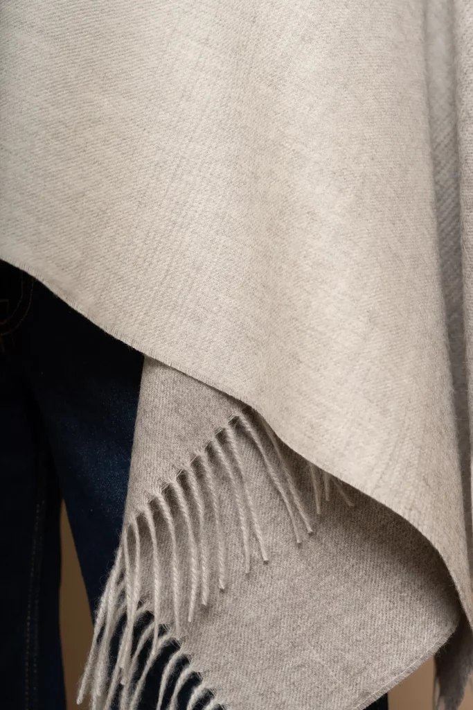 Primer pla d'un xal de llana de baby alpaca gris suau en degradat, luxe unisex fet al Perú per Tukuy