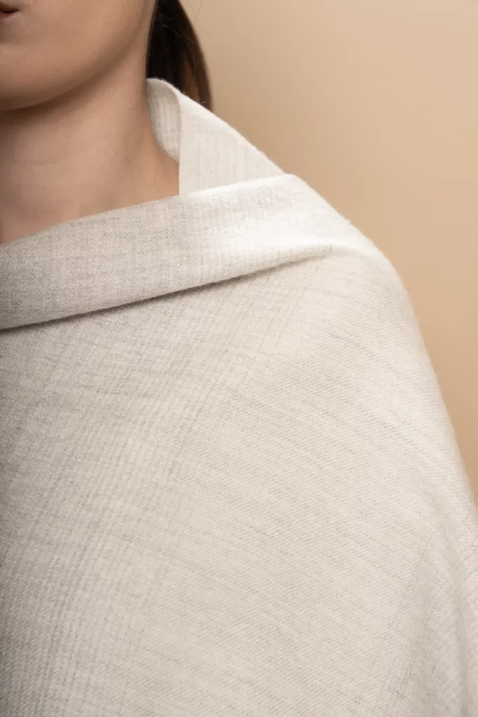 Primer pla d'una dona que porta un xal de llana de baby alpaca gris suau en degradat, unisex de luxe fet al Perú per Tukuy