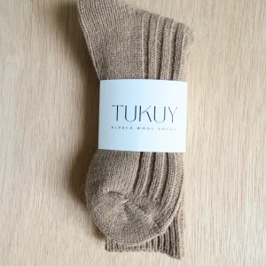 brown alpaca sock made by tukuy on top of a wooden table