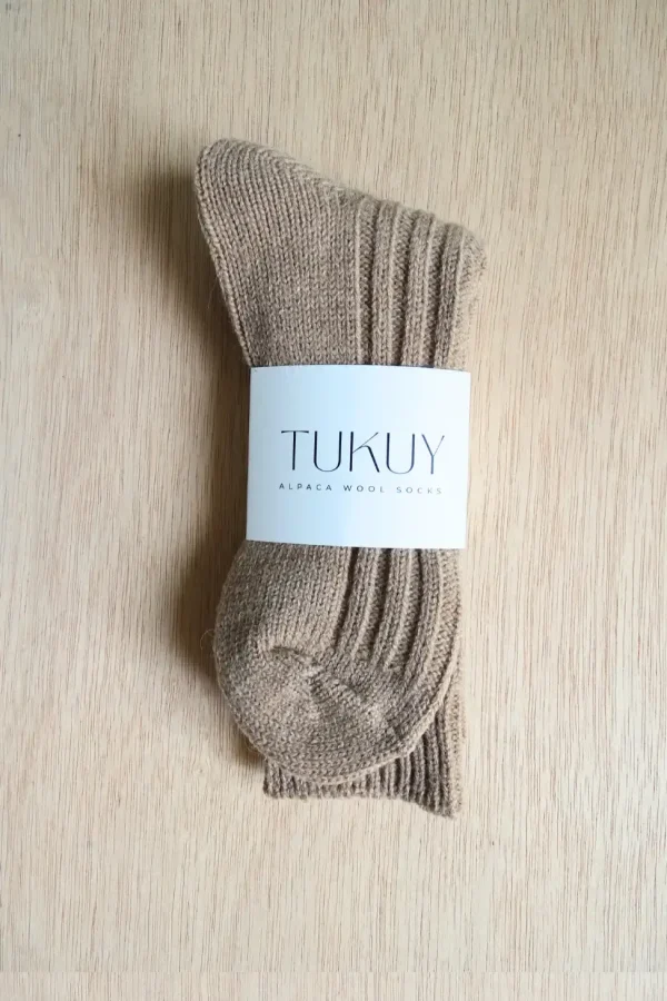 brown alpaca sock made by tukuy on top of a wooden table