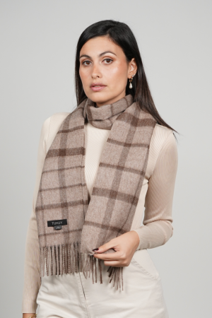 Woman wearing the Alpaca Scarf in Brown Check, featuring a timeless heritage check pattern in warm brown tones that adds character and understated elegance to everyday styling.