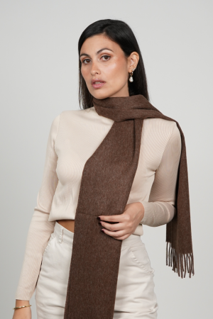Woman wearing a chocolate brown alpaca scarf made from 100% baby alpaca wool, showcasing its rich natural brown color, elegant drape, and timeless winter style.