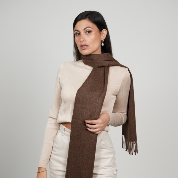 Woman wearing a chocolate brown alpaca scarf made from 100% baby alpaca wool, showcasing its rich natural brown color, elegant drape, and timeless winter style.
