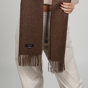 Primer plano de una bufanda de alpaca de color marrón chocolate con flecos, en el que se aprecian su textura suave, los tonos marrones naturales y la excelente calidad de la lana de baby alpaca.