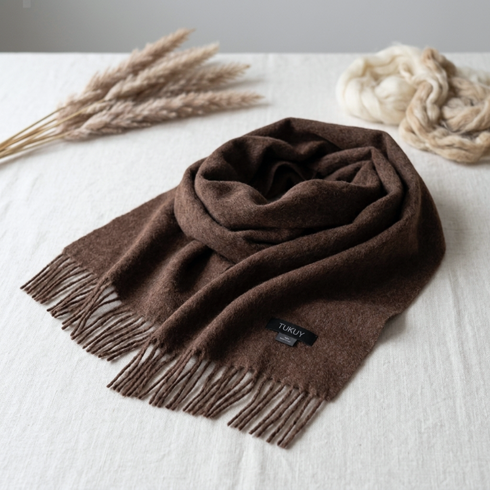Bufanda de lana de alpaca en color marrón chocolate con flecos en los extremos, que destaca el color natural y la suavidad excepcional de la fibra de baby alpaca.