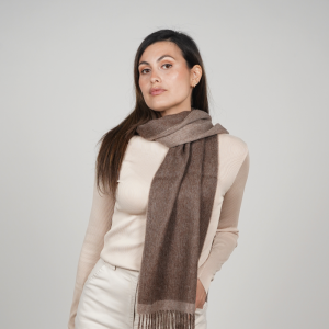 Woman wearing a reversible brown alpaca scarf in natural taupe and chocolate tones, showcasing its elegant drape, soft texture, and versatile neutral color palette.