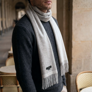 Man wearing a reversible gray alpaca scarf with a charcoal knit sweater, showcasing the scarf's natural gray tones, soft alpaca wool texture, and timeless winter styling.