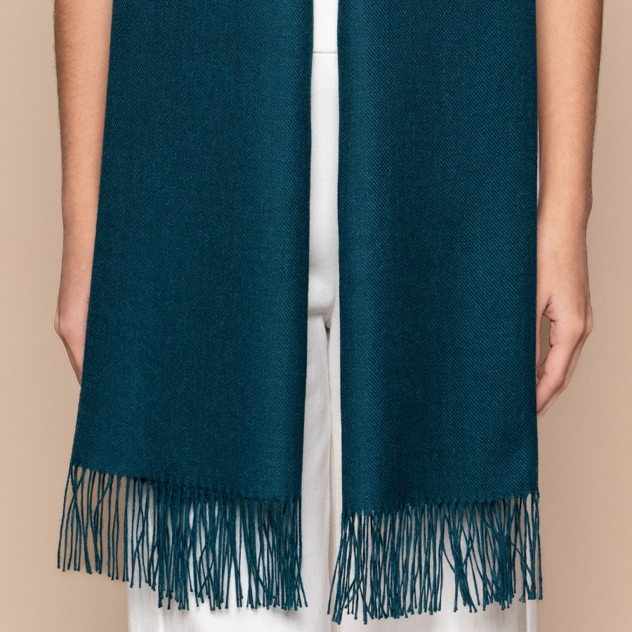 mujer con chalina de alpaca verde mostrando los detalles de tukuy alpaca