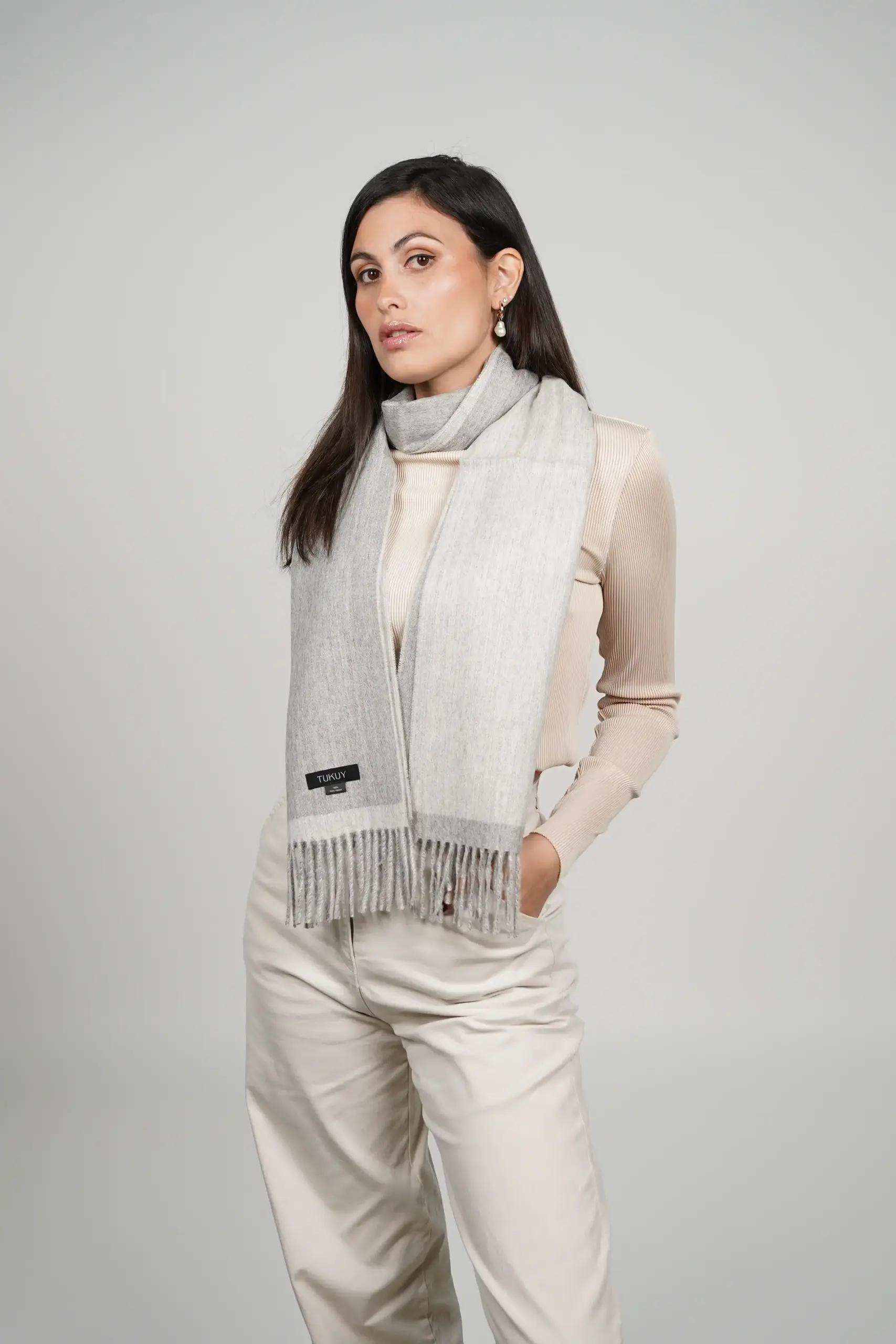 tukuy brand design alpaca scarf in gray tones. two sided scarf in gray. high end luxurious touch alpaca scarf used by a women.