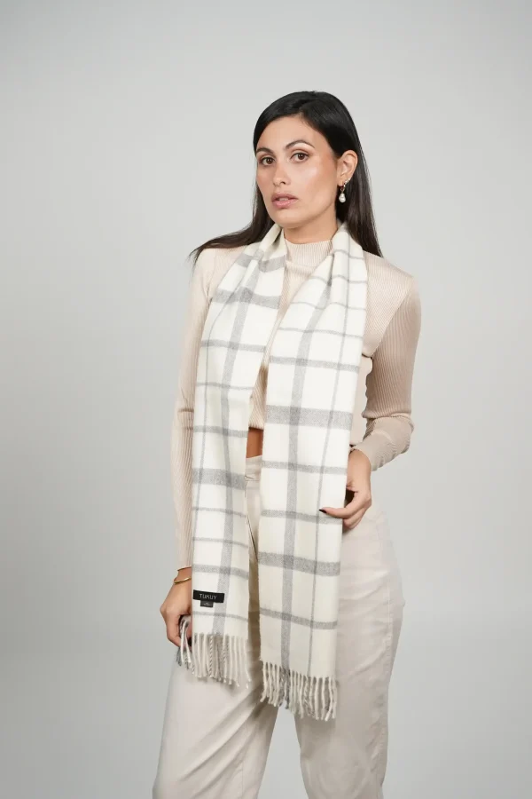 women wearing a check alpaca scarf in white and gray natural tones. Luxurious scarf in natural wool, 100% alpaca wool by tukuy brand