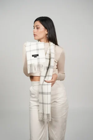 women showing a check alpaca scarf in white and gray natural tones. Luxurious scarf in natural wool, 100% alpaca wool by tukuy brand
