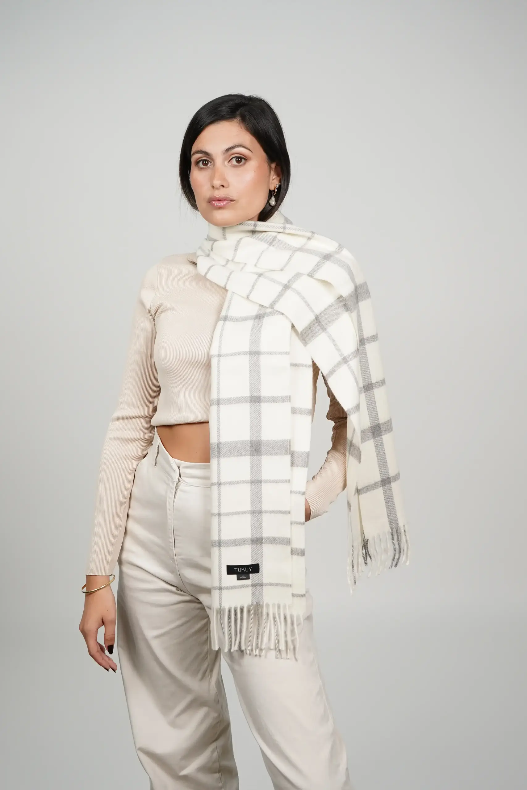 women wearing a check alpaca scarf in white and gray natural tones. Luxurious scarf in natural wool, 100% alpaca wool by tukuy brand