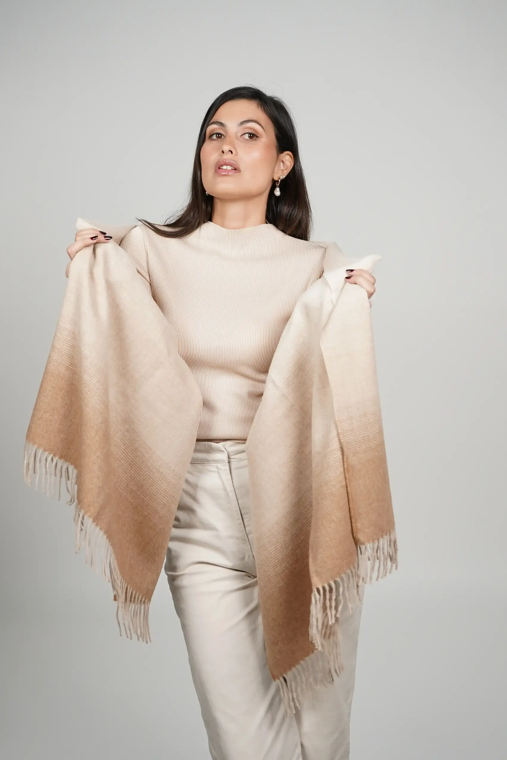women wearing a beige alpaca shawl in natural color of alpaca wool. luxurious touch and nice drape by tukuy brand
