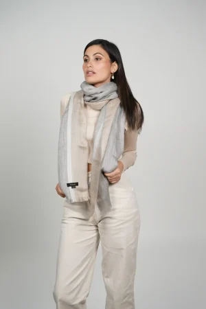 women wearing a gray and beige alpaca shawl with silk. Alpaca and silk shawl made by Tukuy Brand
