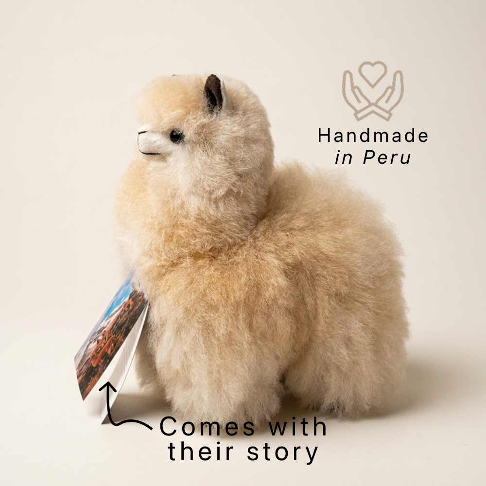 alpaca plush handmade in peru by artisans with a text "handmade in Peru" and "comes with their story" in a studio picture