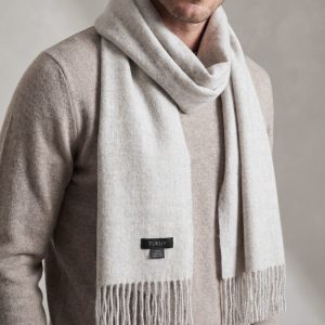 Man wearing the Ayllu light gray alpaca scarf crafted in Peru from 100% baby alpaca wool.