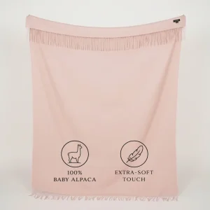 Baby pink baby alpaca blanket with fringed edges laid flat – luxurious Peruvian alpaca wool throw in a delicate pastel pink color