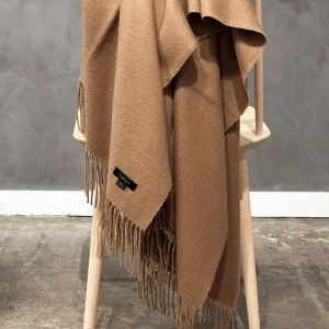 Camel baby alpaca blanket draped over a wooden stool – premium Peruvian alpaca wool throw with soft fringes