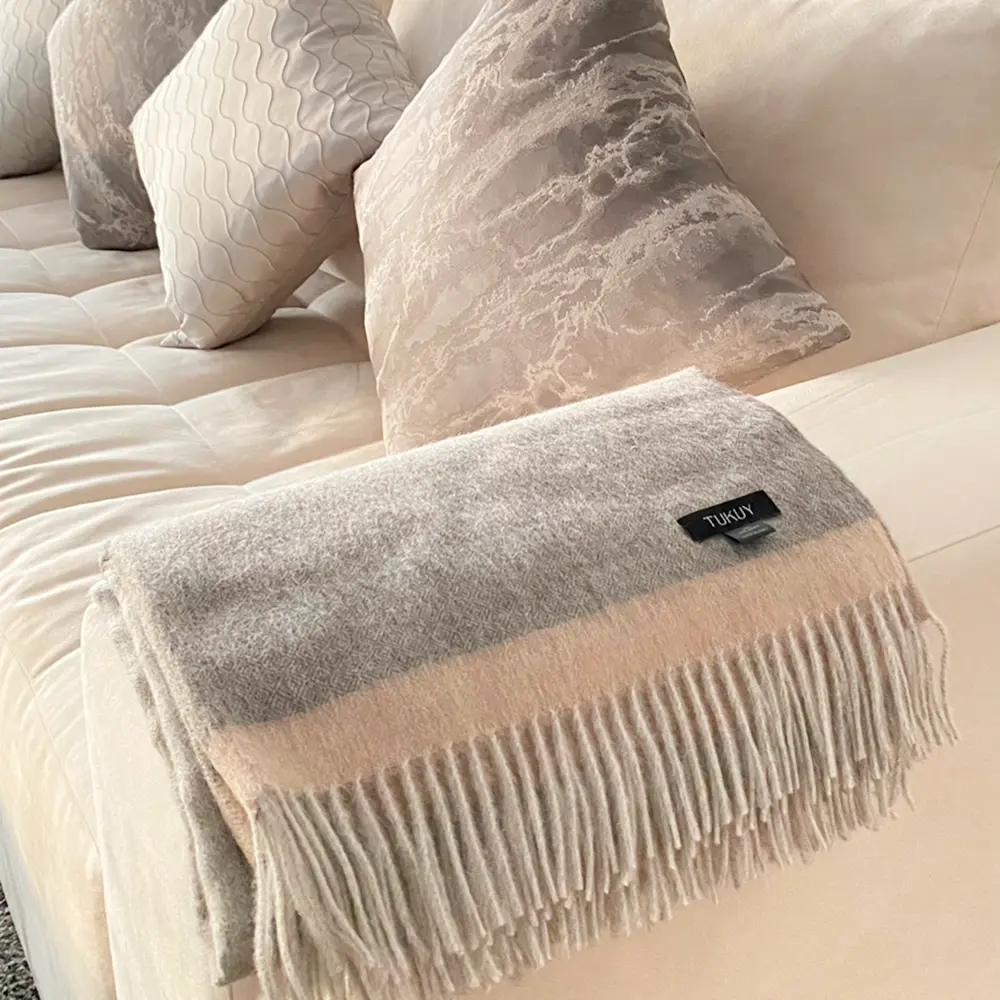 Baby alpaca blanket in grey folded on a sofa showcasing its soft texture in modern home