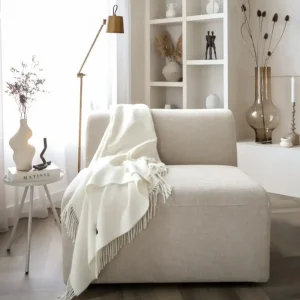 Baby alpaca blanket in white styled on a sofa in a bright modern living room