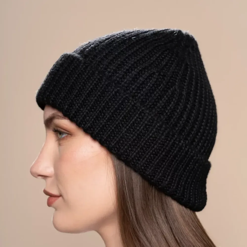 Woman in profile wearing a black knitted alpaca beanie