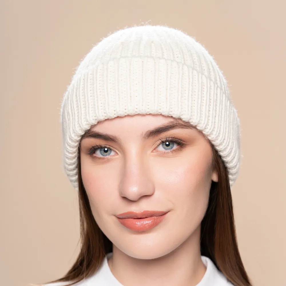women wearing a white knitted alpaca beanie in a neutral background