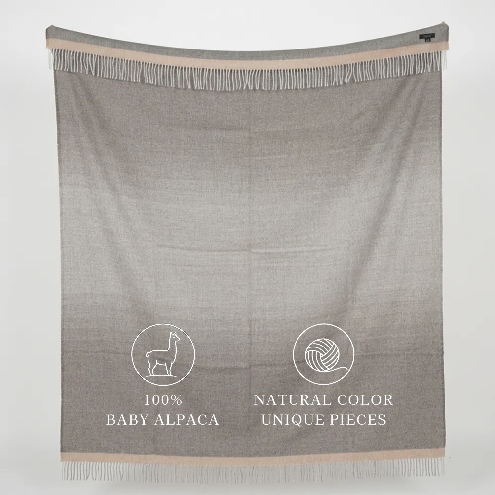 Gray fringed alpaca blanket labeled “100% Baby Alpaca” and “Natural Color Unique Pieces.”