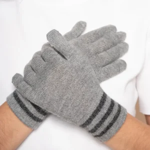 Gray knit alpaca gloves with striped cuffs crossed over a person's arms