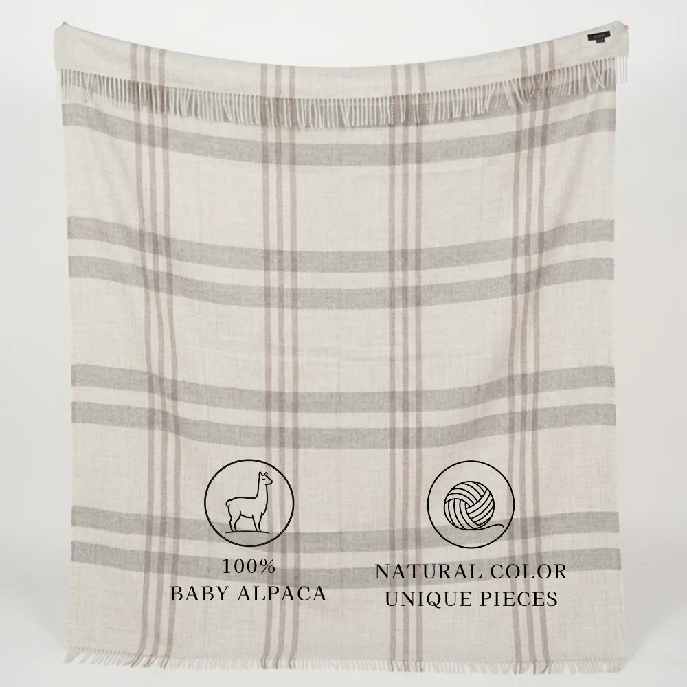 gray plaid fringed textile labeled “100% BABY ALPACA” and “NATURAL COLOR UNIQUE PIECES”
