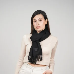 Baby alpaca scarf in black worn with a cream sweater