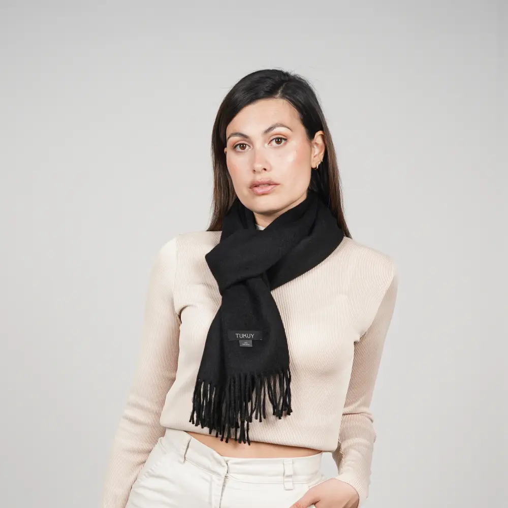 Baby alpaca scarf in black worn with a cream sweater