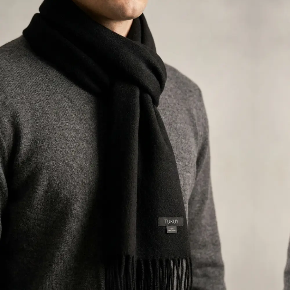 Baby alpaca scarf in black worn by a man with a grey sweater