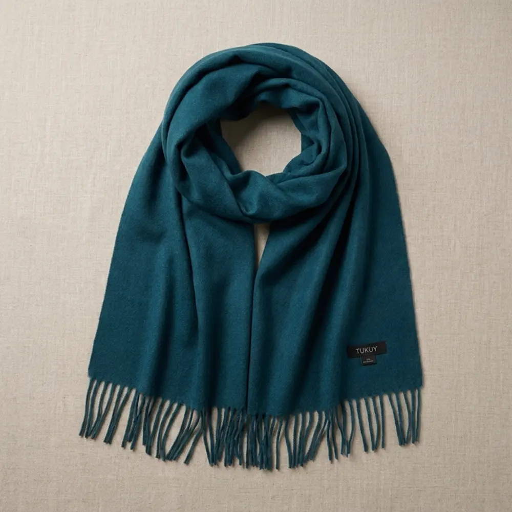 Baby alpaca scarf in green folded on a neutral background showcasing its elegant design