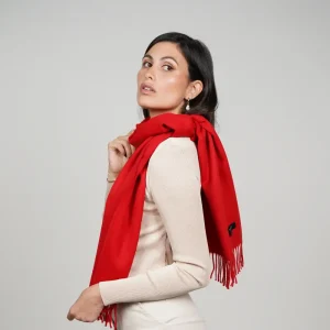 Baby alpaca scarf in red worn over the shoulder by a woman