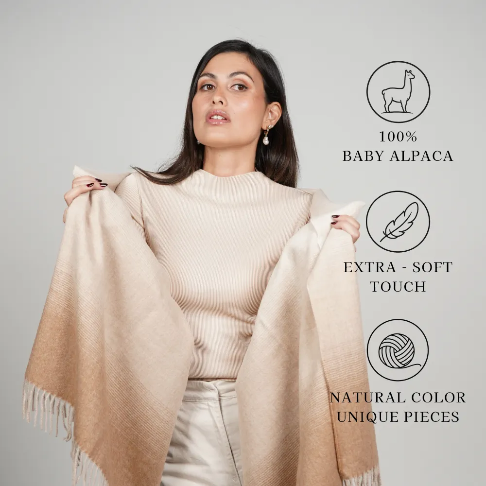 Model wearing a beige shawl labeled “100% baby alpaca,” “extra-soft touch,” and “natural color unique pieces.”