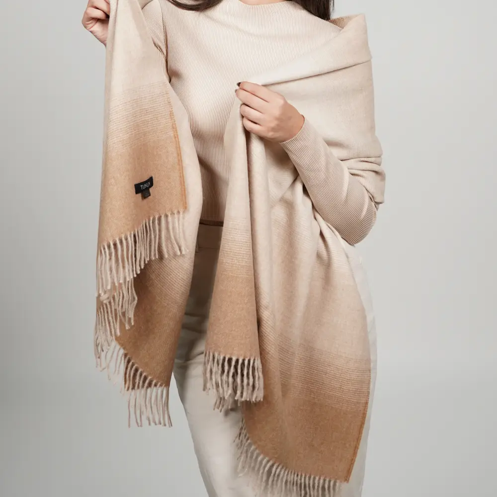 Baby alpaca shawl in gradient brown draped over the shoulders with fringe details