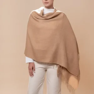 Baby alpaca shawl in beige worn as a wrap over a white outfit