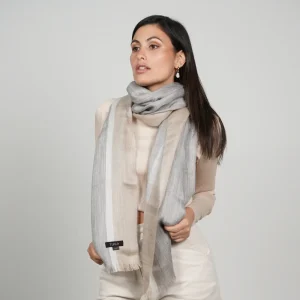 Baby alpaca shawl in grey and brown worn with a cream sweater showcasing its elegant design
