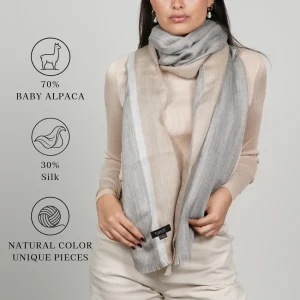 Model wearing a natural-color shawl labeled 70% baby alpaca and 30% silk; text says “Natural color, unique pieces.”