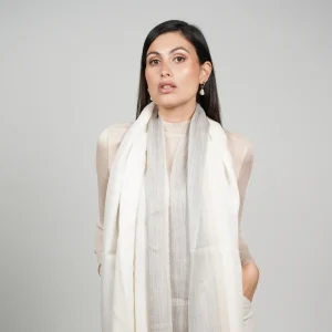 Baby alpaca and silk shawl in grey and white worn with a cream sweater